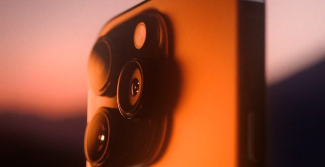 من iPhoneIslam.com، صورة مقربة لجهاز iPhone 11 عند غروب الشمس.