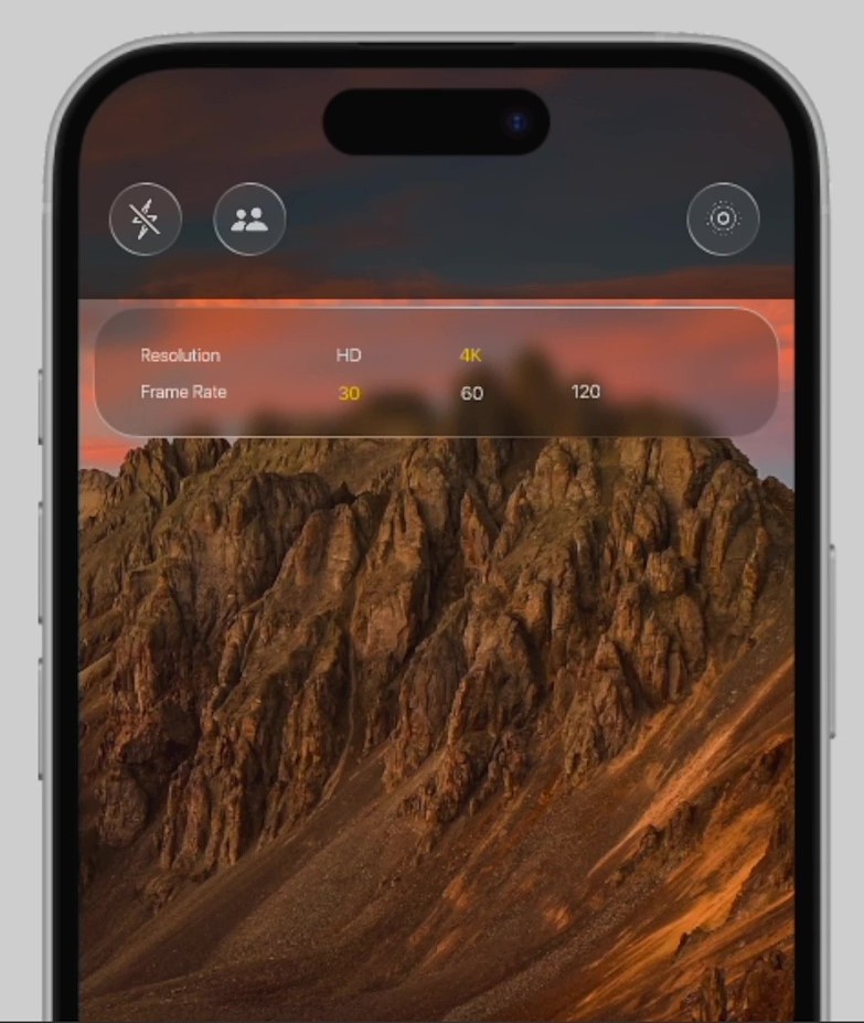 من iPhoneIslam.com، تعرض شاشة الهاتف الذكي بنظام التشغيل iOS 19 إعدادات الكاميرا فوق منظر جبلي صخري، وتوفر خيارات سهلة الاستخدام مثل دقة HD و4K إلى جانب خيارات معدل الإطارات 30 و60 و120.